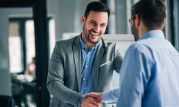 Ein Mann schüttelt einem anderen Mann die Hand. Business Coaching Frankfurt.